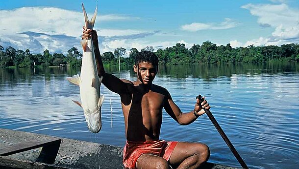 Junge in Amazonien mit Fisch