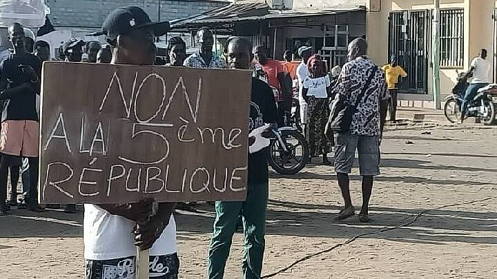 Proteste in Togo. Ein Demonstrant halt ein Transpi hoch mit der Aufschrift "Nein, zur 5. Republik"