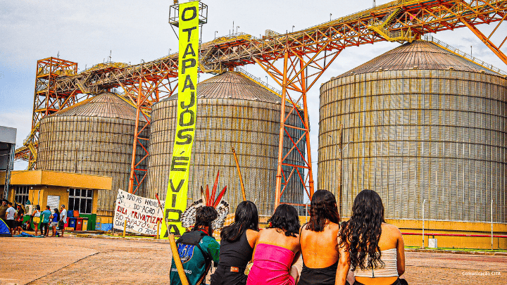 Cargill-Terminal mit Banner "O Tapajos" im Vorderung sitzen 4 Frauen