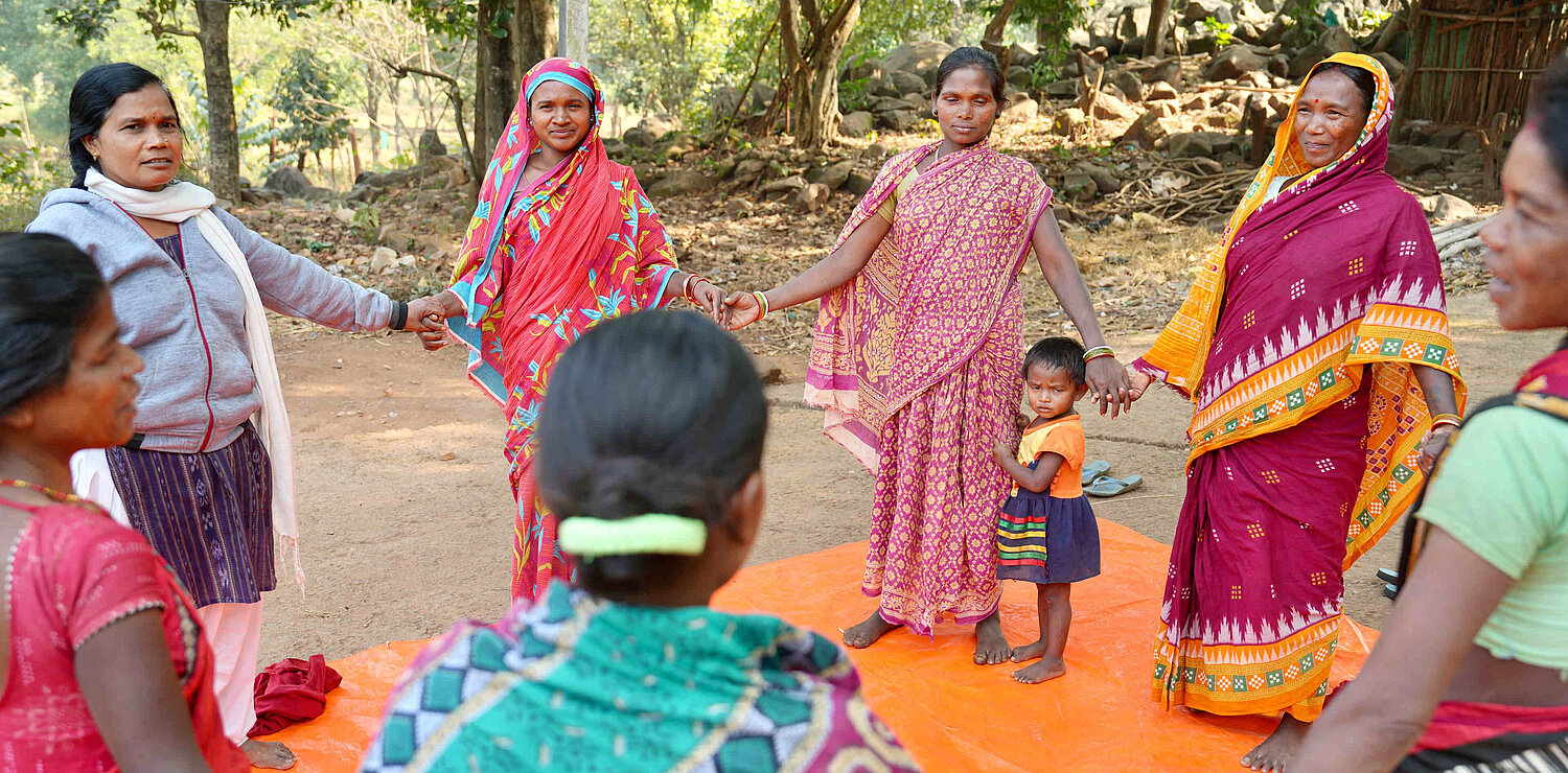 eine Gruppe indischer Frauen steht im Kreis
