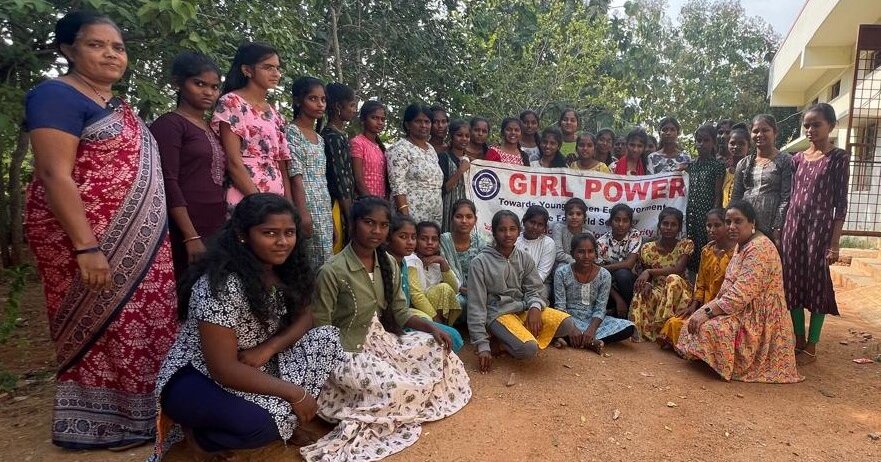 Eine Gruppe indischer Frauen und Mädchen, Sie haben ein Plakat mit "Girl Power" in der Hand