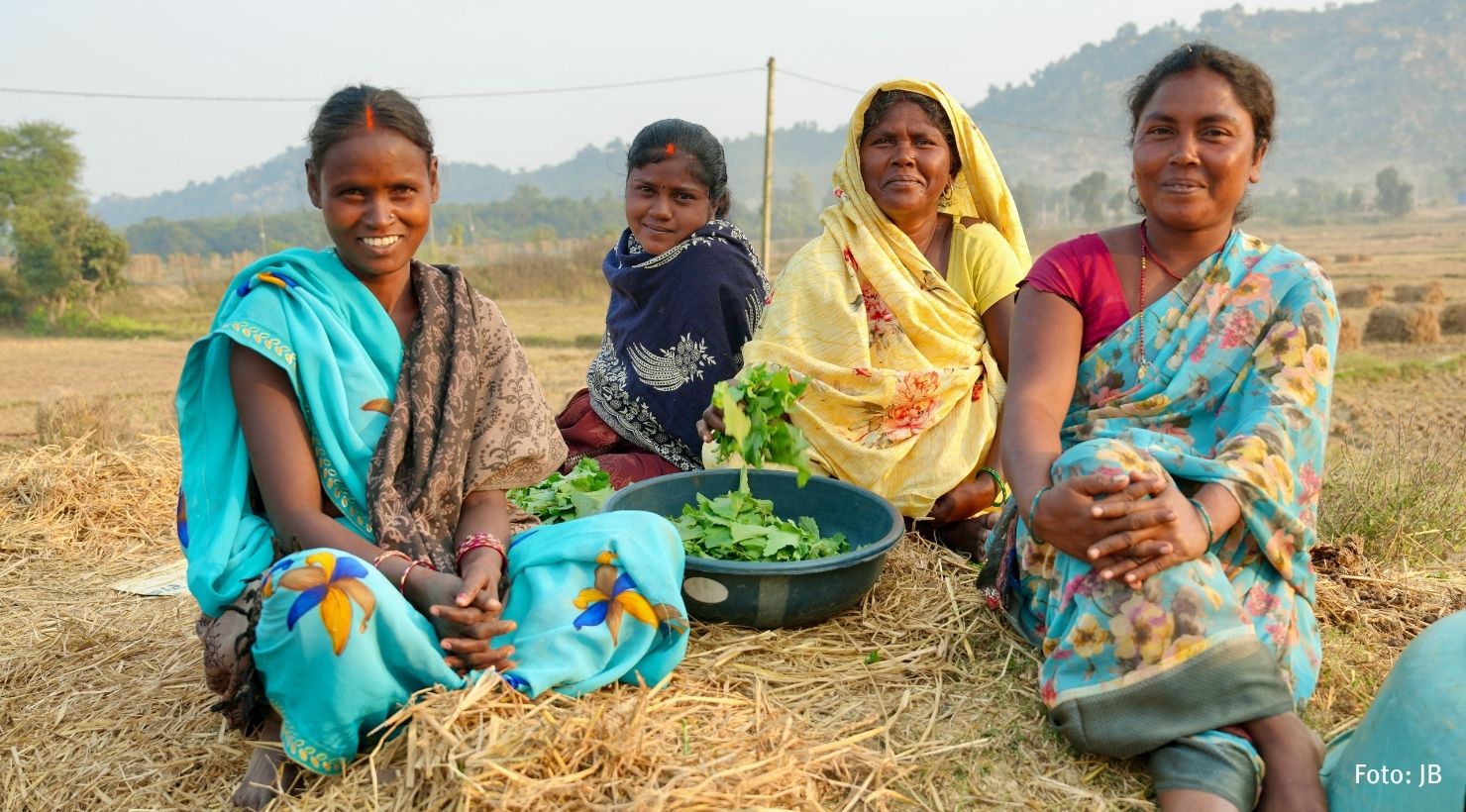 4 indische Frauen sitzen auf dem Feld