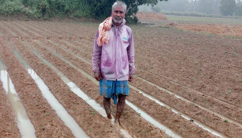 Mann watet durch nasses Feld