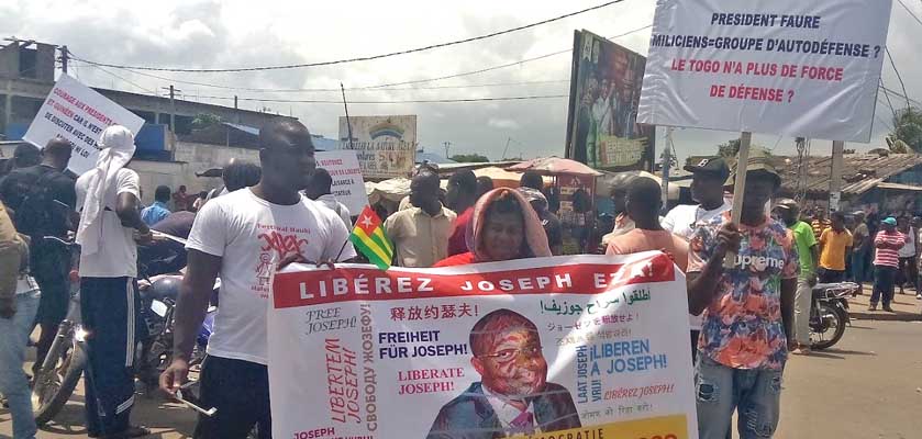 Eine Demo in Togo, mehrere Leute mit Transpis